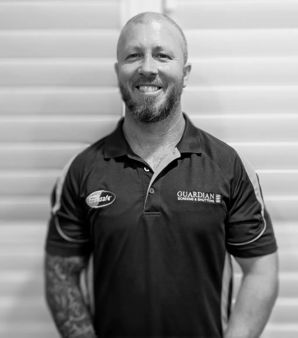 Clinton, a Guardian Screens & Shutters installer, in a Guardian and Crimsafe work shirt
