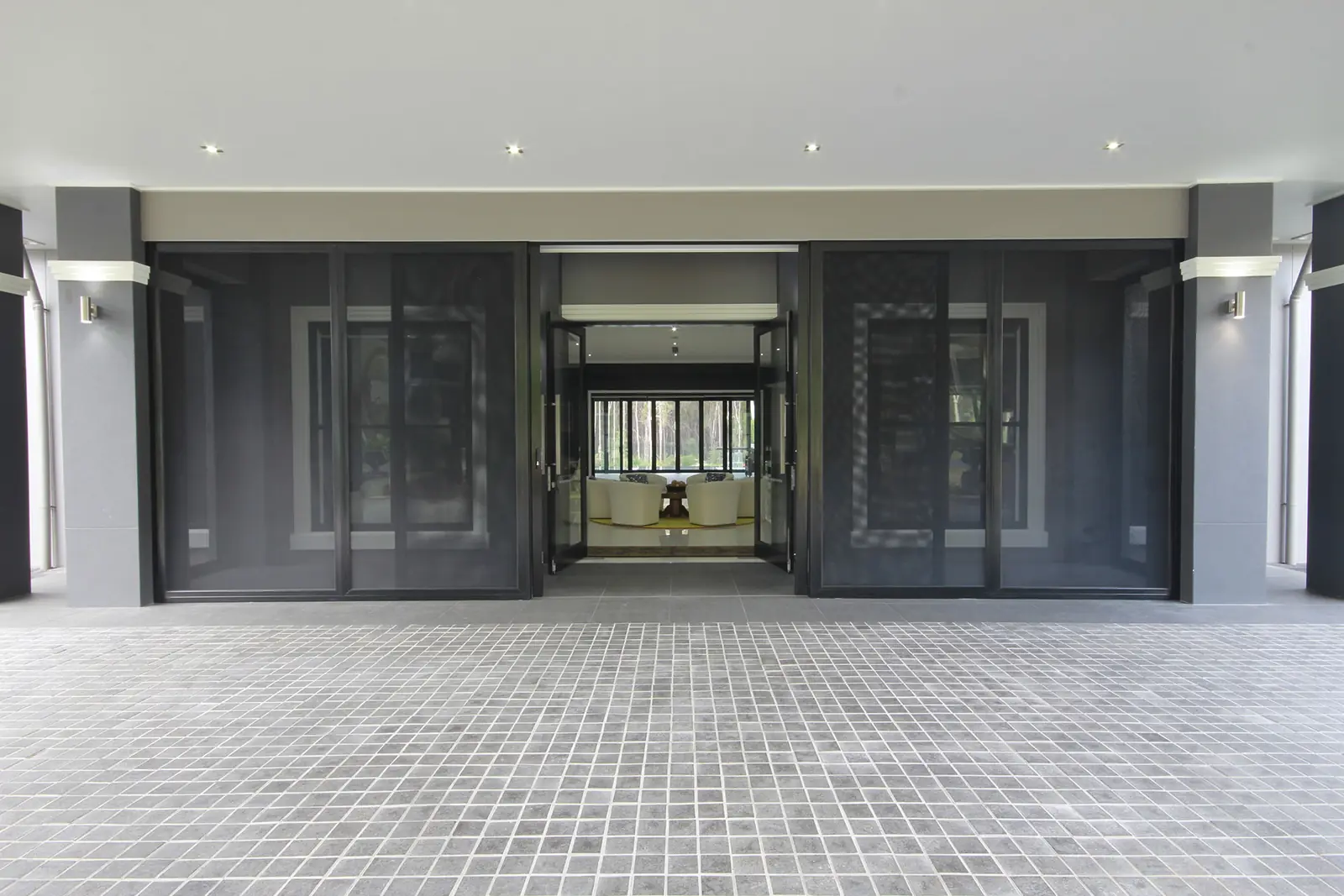 Crimsafe stacker doors across the back of a Brisbane home, the centre pair standing open to the living room
